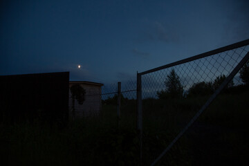 Mesh iron fence gate in the dark night under the moon light