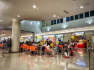 defocused back of crowded people enjoying their time with family or friends in food court of modern market