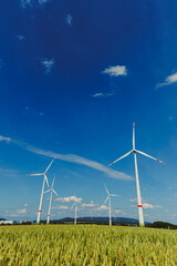 Wind Turbines Standing Proudly in a Beautiful Scenic Landscape Beneath an Expansive Clear Blue Sky...