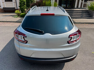 A sleek and stylish silver compact SUV is parked in a bright outdoor setting, which features a...