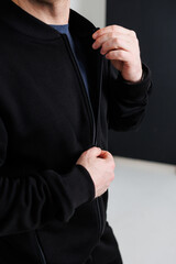 Casual Fashion A stylish man is showcasing a black jacket that features a modern design with a...