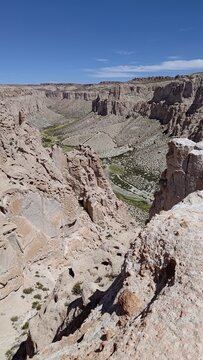Valle de Rocas, Bolivia. Expansive view of a deep rocky canyon in a desert landscape, with unique geological formations, and a green valley floor. A remote and arid wilderness perfect for adventure.