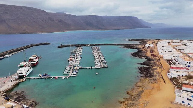 Drone image of Caleta de Sebo white coastal homes set against La Graciosa volcanic terrain