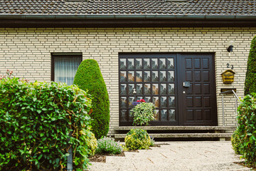 The charming and inviting modern entrance of a beautiful residential home is gracefully surrounded...