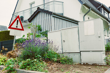 This is a residential area that features a clear warning sign along with utility boxes, all...
