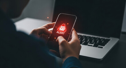 Close-up of hands holding smartphone displaying red alert notification, showcasing urgency and digital communication, symbolic of immediate attention needed