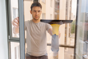 Focused janitor cleaning window with cordless vacuum cleaner, achieving spotless, streak-free shine in professional environment while maintaining high standards of hygiene and cleanliness.