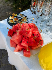 A beautifully arranged plate of fresh, juicy watermelon sits invitingly on a table, alongside...