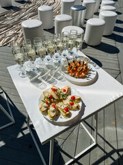 A beautiful table adorned with an array of delicious plates of food and elegant wine glasses neatly arranged on it, creating an inviting and delightful atmosphere for dining