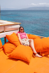 Sunny afternoon relaxation on a boat with bright orange cushions by a crystal clear ocean