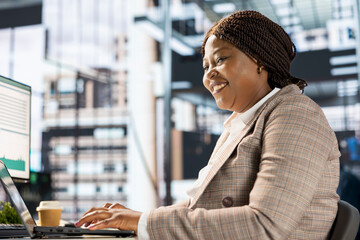 Focused african american general manager multitasking at desk to solve business tasks and...
