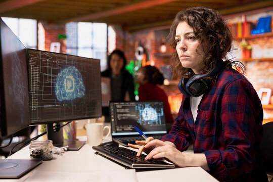 Programmer coding in fast paced AI startup office, building scalable solutions for businesses. AI industry startup technician leveraging machine learning technology in workspace