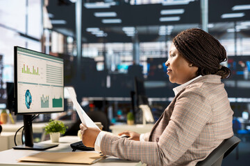 Focused african american general manager multitasking at desk to solve business tasks and...