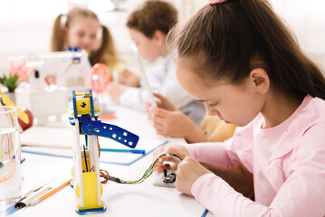 Stem education. Girl working with wires and circuits on robotics project