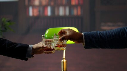 Old money heirs clinking glasses of whiskey and toasting for their partnership after a negotiations...