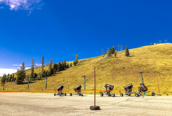 Idle snow machines eagerly awaiting freezing weather, at a ski resort in the mountains of the...
