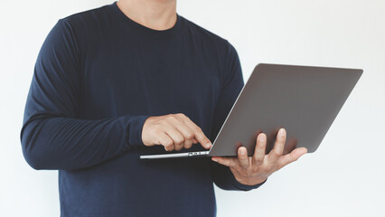 A man standing and using a laptop computer isolated on a white background. Remote work, modern business, digital lifestyle, education, online learning, entrepreneurship and technology in everyday life