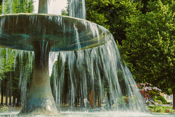 A Majestic Water Fountain, Elegantly Surrounded by Lush Greenery, Nestles Comfortably in a...