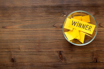 Glass jar full of folded paper sheets with raffle ticket winner