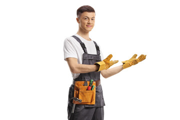 Young repairman with a tool belt gesturing welcome