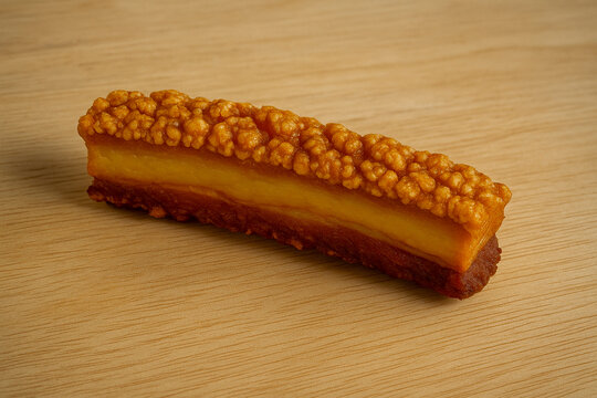 Breaded Fish Stick with Golden Crust on Wooden Table Close-Up