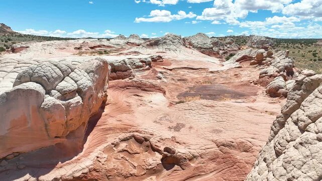 Aerial White Pocket Rock Formations Fly Through Over Red and White Sandstone