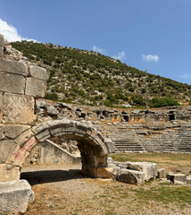 Ancient ruins and amphitheater surrounded by hills on a sunny day
