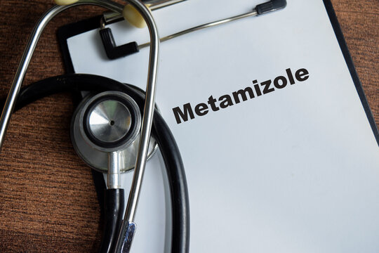 Concept of metamizole write on clipboard isolated on Wooden Table.