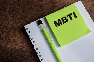 Concept of MBTI write on sticky notes psychological study and research isolated on Wooden Table.