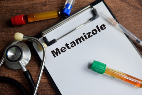 Concept of Metamizole write on clipboard isolated on Wooden Table.