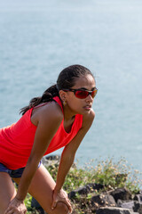 Young latin woman stretching body after jogging - stock photo