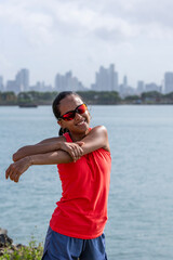 Young latin woman stretching body after jogging - stock photo