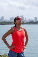 Young latin woman stretching body after jogging - stock photo