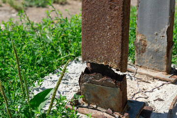 Rusty broken steel column base — corrosion damage of metal support post