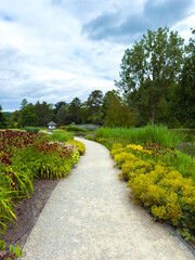 A beautiful and serene garden pathway, adorned with vibrant flowers and surrounded by lush...