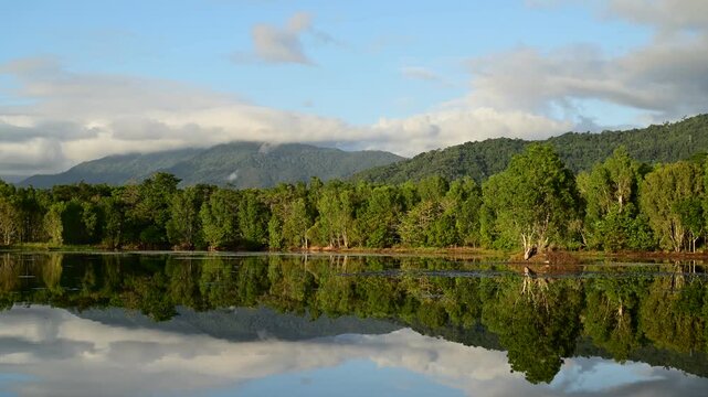 Early morning timelapse at Lake Jabiru in the Cattana Wetlands, north of Cairns, Queensland, with mist rising over still water and the Macalister Range forming a tranquil backdrop