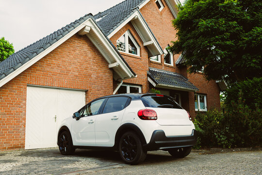 A modern family home featuring a stylish car parked gracefully in the driveway, showcasing a perfect combination of comfort, elegance, and thoughtful design elements throughout the property