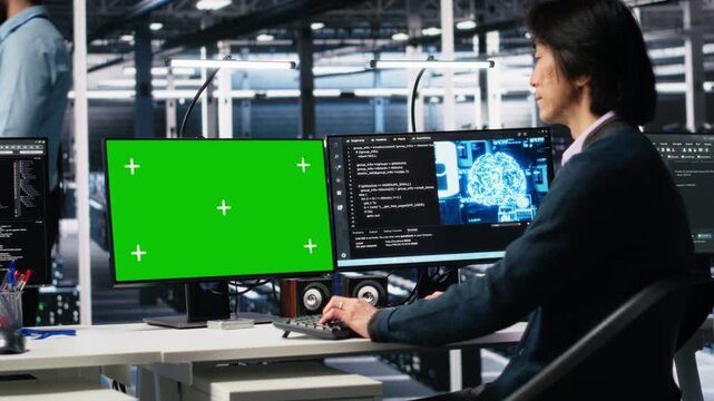 Data center admin typing on isolated screen PC keyboard, using AI. IT specialist at work using artificial intelligence on chroma key computer to oversee servers powering deep learning, camera A