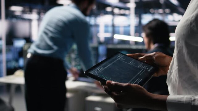 Close up of data center programmer using tablet, writing code for resource optimization, performing updates. Server room employee using device, compiling software patches to fix bugs, camera A