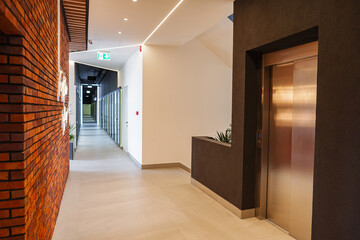 Long Hallway With Metal Door and Planter