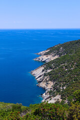 Fototapeta premium Rocky coastline with lush green hills