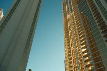 Tall sky scraper hotel buildings basked in golden yellow light during sunset golden hour