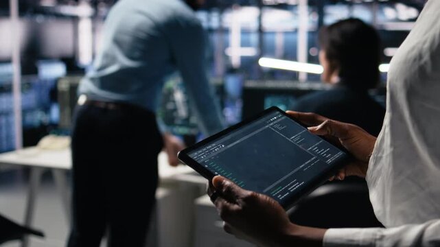 Close up of data center software developer using tablet to review code for automation scripts. Server hub IT specialist using device, monitoring error logs for debugging processes, camera A