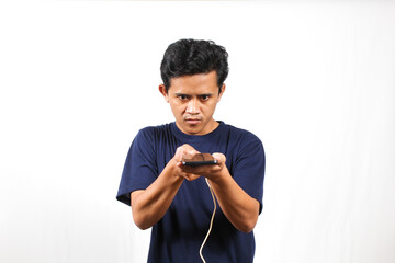 Asian man wearing navy t-shirt holding smartphone inserting rechargeable power cable isolated on...