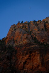 Zion national park emerald pools hike cliff with moon out during evening time