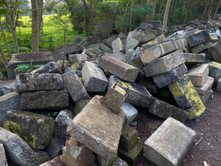 Pile of left over concrete block, concrete masonry blocks, messy arrangement, green trees surrounding
