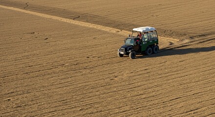 Obraz premium a tractor is driving through a ploweded field