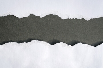 Torn white paper into half on top of black background, copy space.