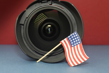 Camera lens with miniature American flag on red and blue background