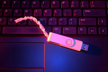 USB drive with keychain sitting on a computer keyboard